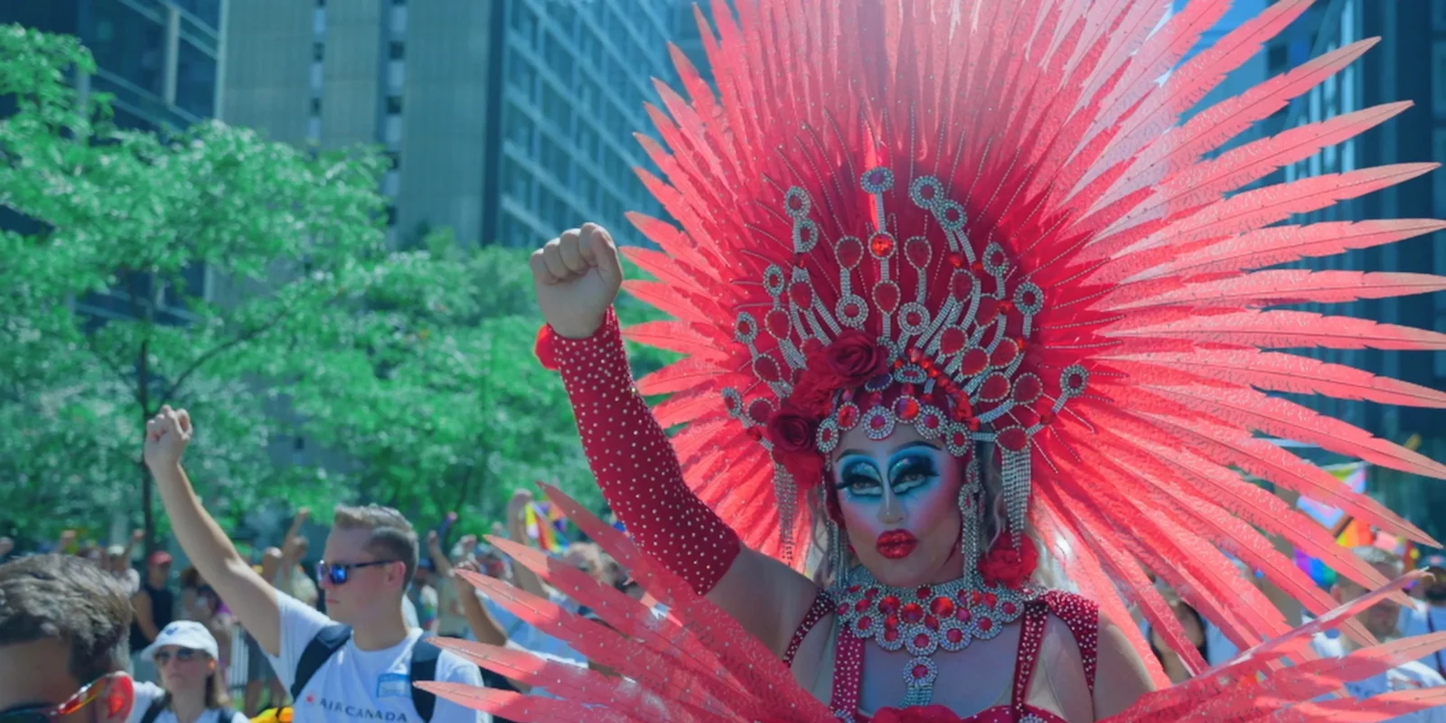 Moh Dafok at a Pride parade, raising a fist in a gesture of power.